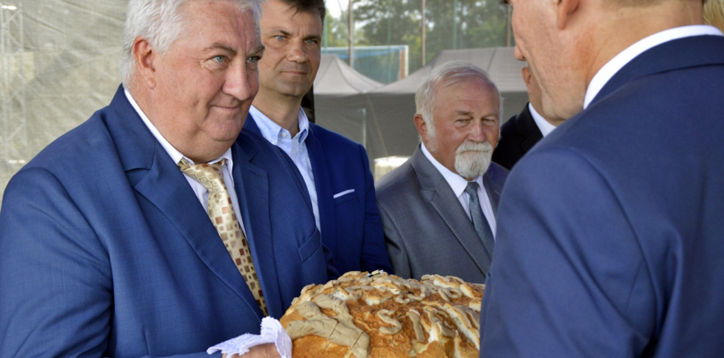 Po Mszy św. polowej i poświęceniu wieńców dożynkowych gospodarze imprezy podzielili się z innymi uczestnikami chlebem z tegorocznych plonów [Foto: Bartosz Jasiówka] 