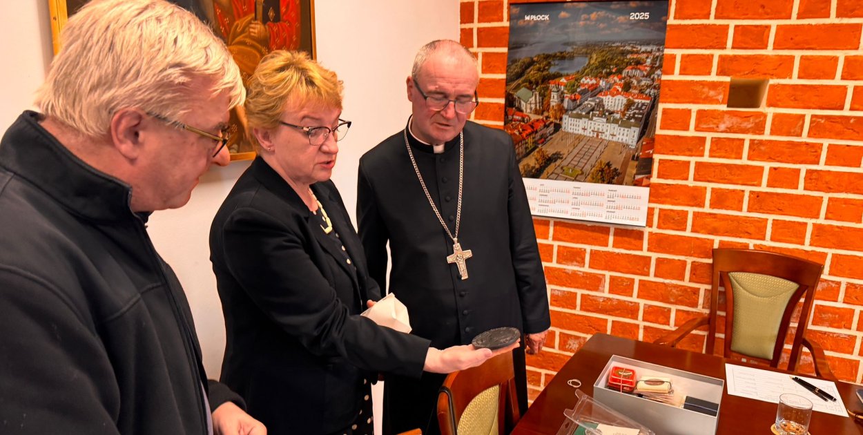 Na ręce biskupa płockiego Szymona Stułkowskiego katechetka ze Szczytna przekazała kolekcję związaną ze św. Janem Pawłem II [fot.: Wydział Katechetyczny Kurii Diecezjalnej Płockiej]